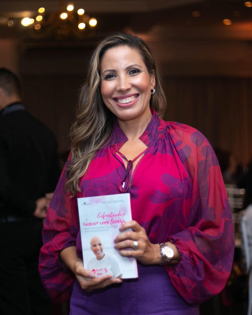 Patrícia Figueiredo segurando o livro Enfrentando o Câncer com Leveza